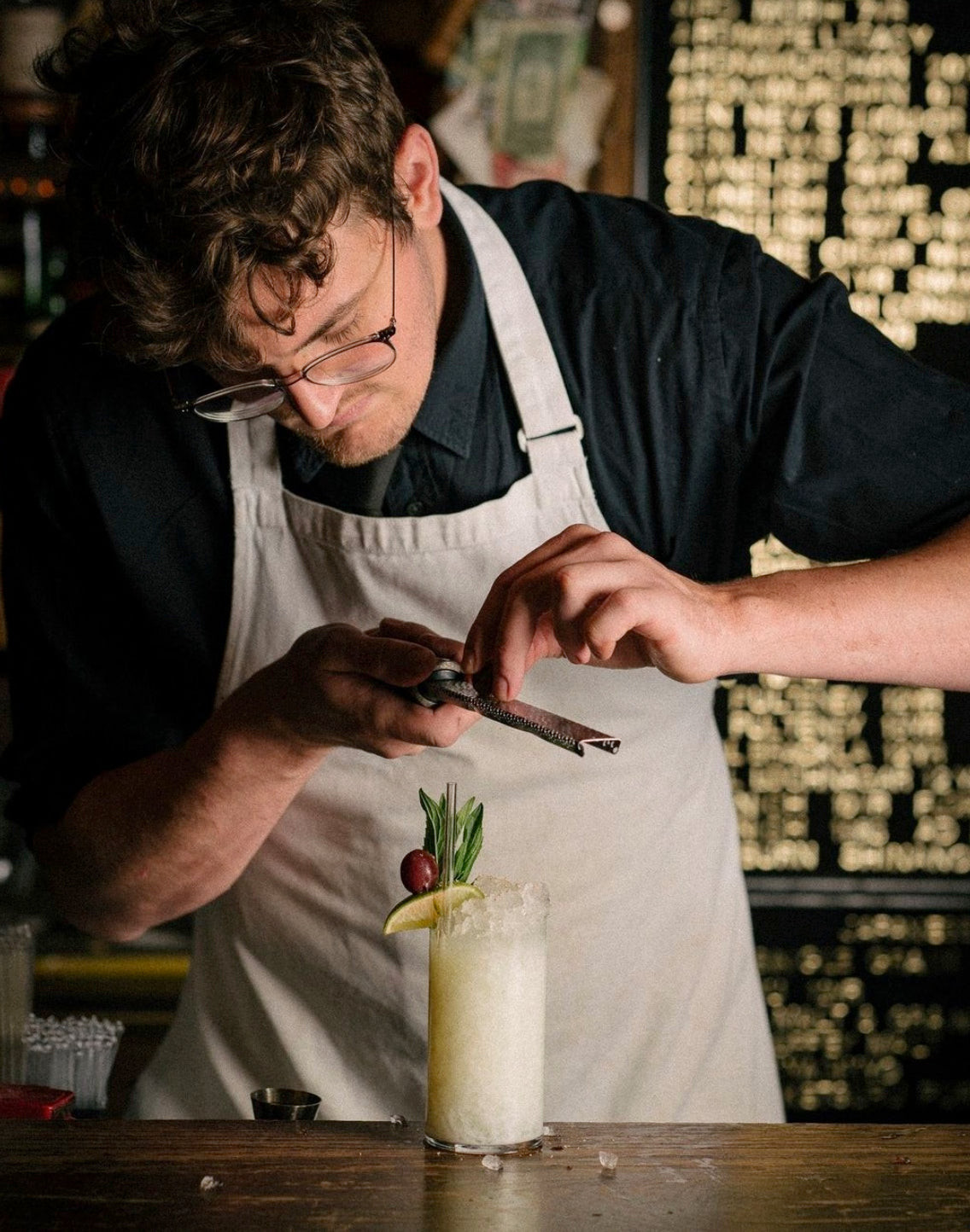 Close-up of bartender uniform at The Baxter Inn, showing the detail of the white canvas apron and dress shirt, reflecting Australian casualness and speakeasy style.