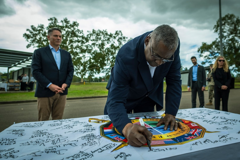 U.S. Secretary of Defense signs the Exercise Talisman Sabre flag, symbolizing commitment to allied partnerships.