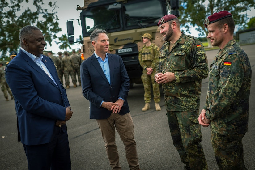 Defense leaders engage with German service members in Australian military exercise, fostering international relationships.