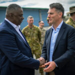 Australian and U.S. military leaders shake hands during Exercise Talisman Sabre, highlighting international cooperation.