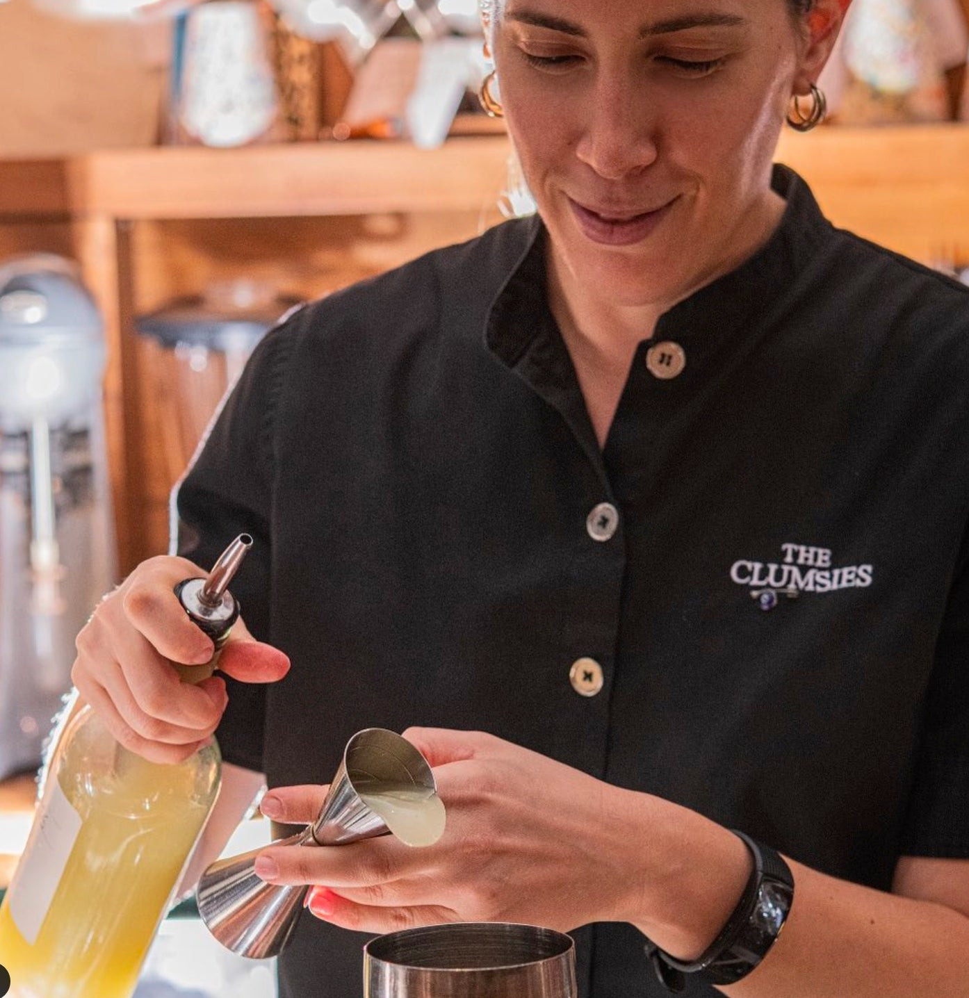 Bartender at The Clumsies with a leather apron, adding a touch of ruggedness to the otherwise casual bartender uniform.