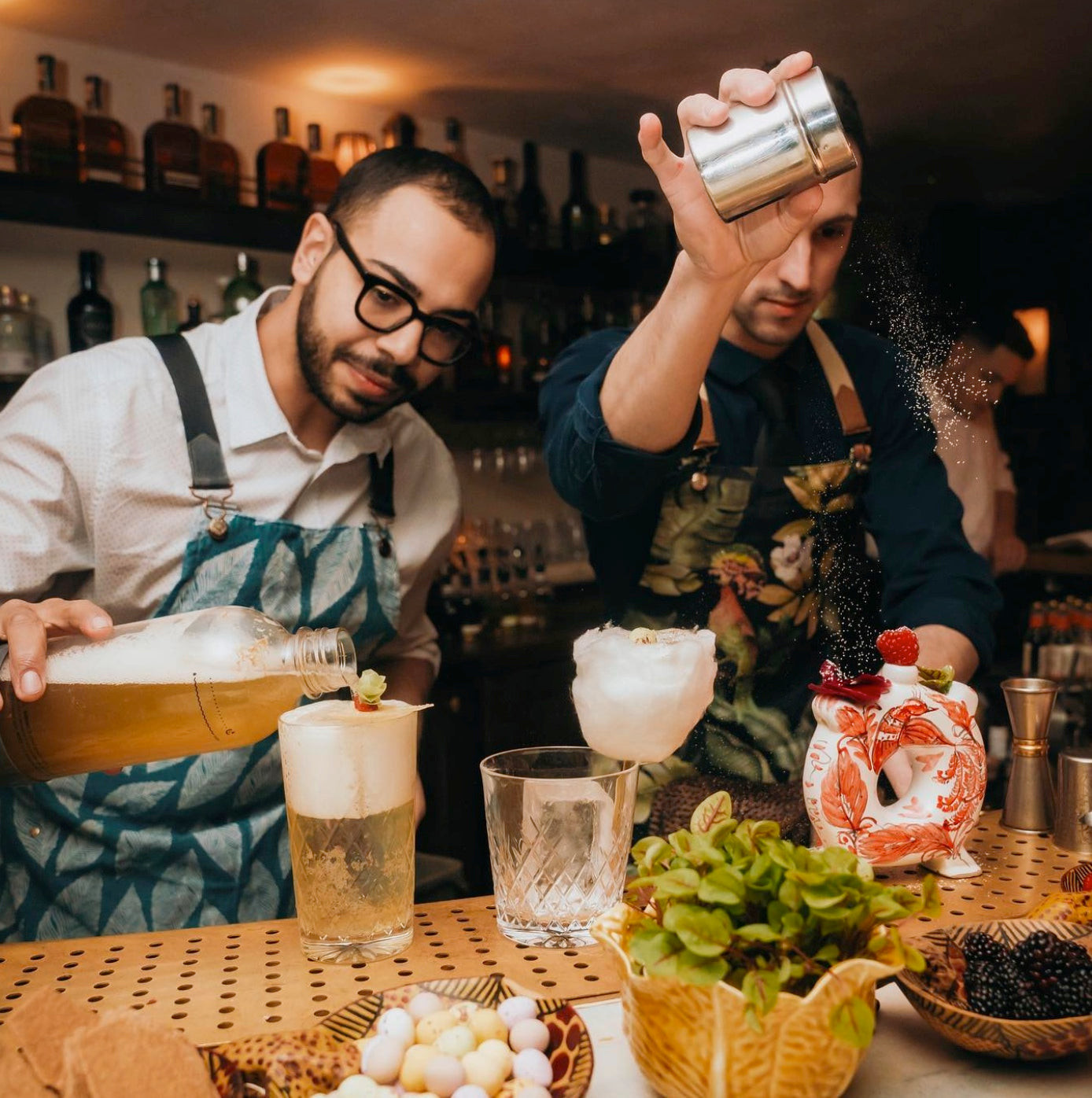Bartender at Nightjar in a denim apron with yellow stitching, offering a contrasting and visually striking bartender uniform design.