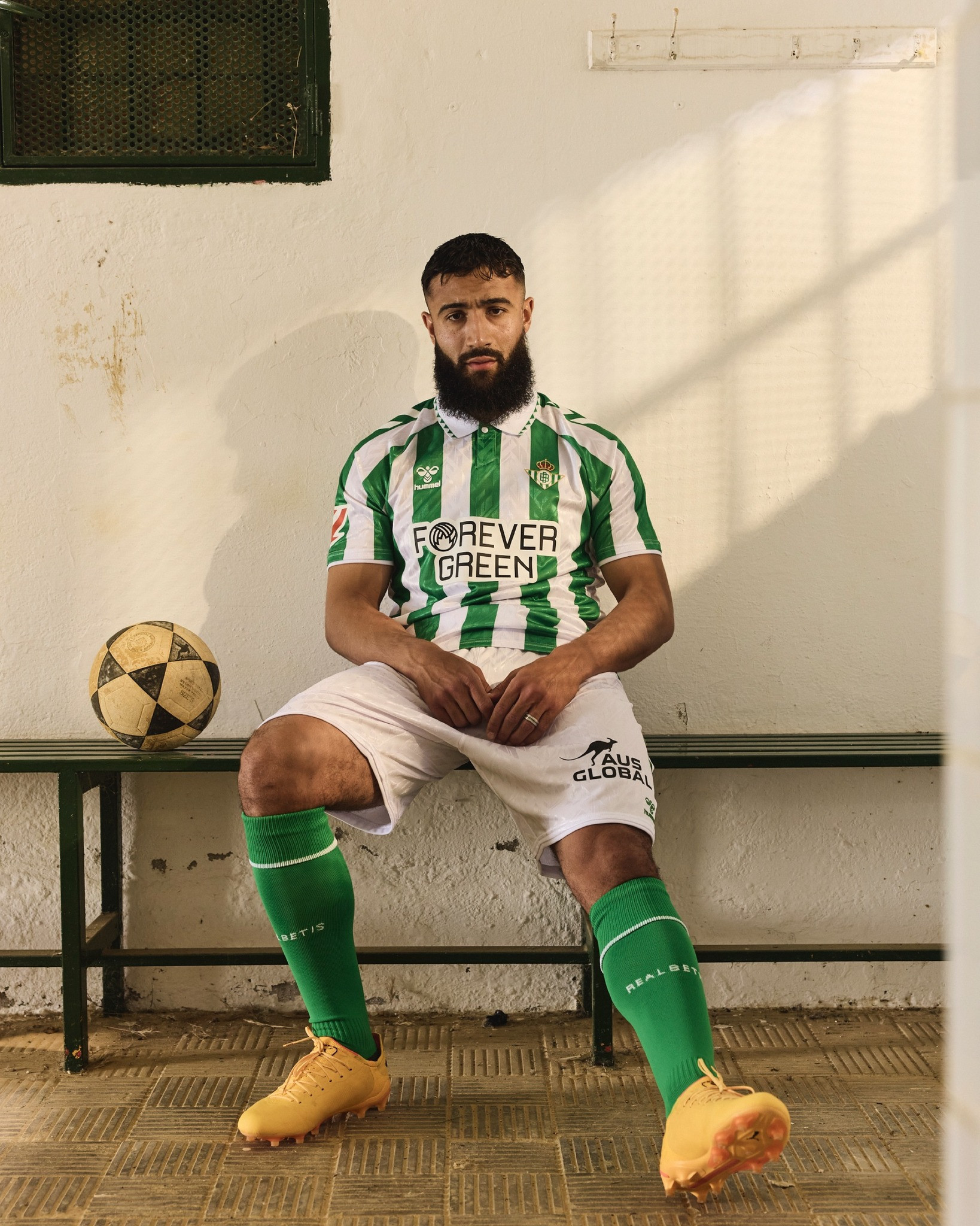 Real Betis 2024-2025 Home Jersey: Classic green and white stripes by Hummel.
