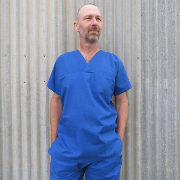 Close-up of a man wearing a scrub top from the free uniform patterns, focusing on the simple V-neck design.