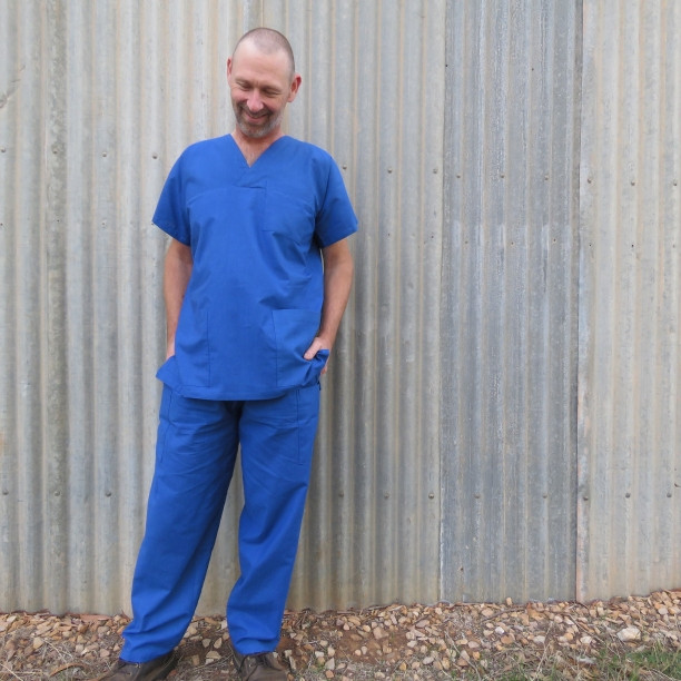 A man wearing free scrub uniform patterns, showing how the design works for different body types.