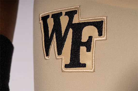 Wake Forest Demon Deacons football uniform side view, highlighting sleeve and pant stripe details.